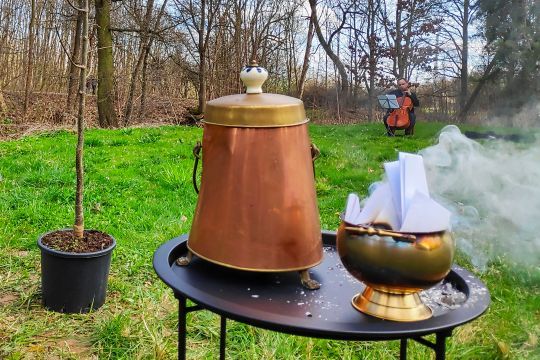 pohřební obřad: popel, pálení vzkazů, urna, violoncello, sázení stromu