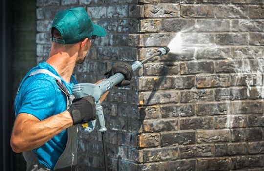 pressure washing bricks on a house