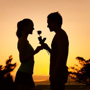 silhouette of man giving a woman a rose