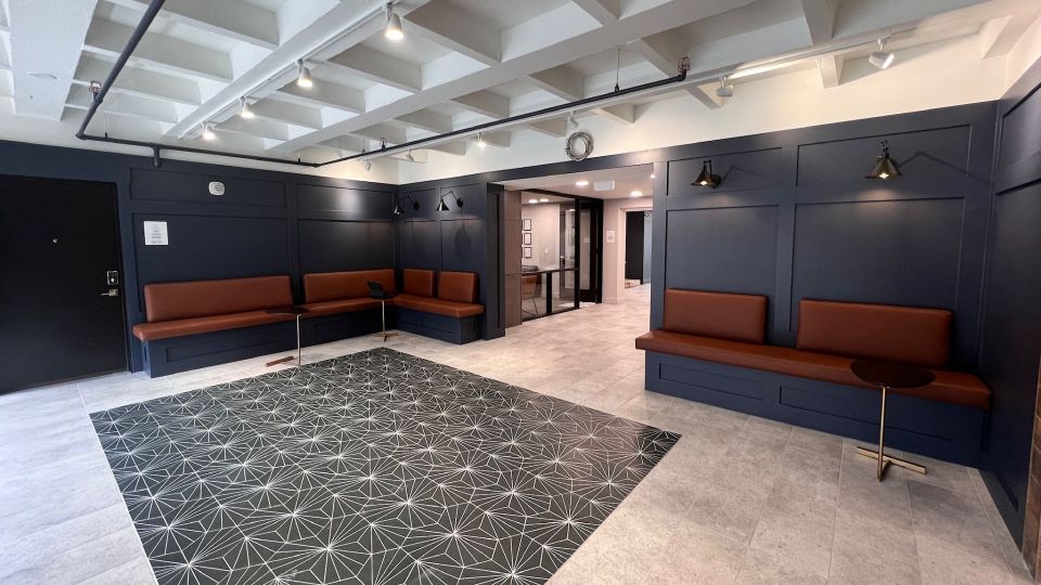 Large art deco style lobby entrance area with built in cafe-style benches and tables.