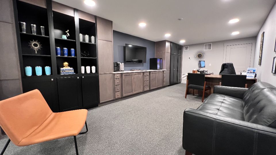 View of business center with art deco style decor and conference table next to fitness room and lobby entrance.