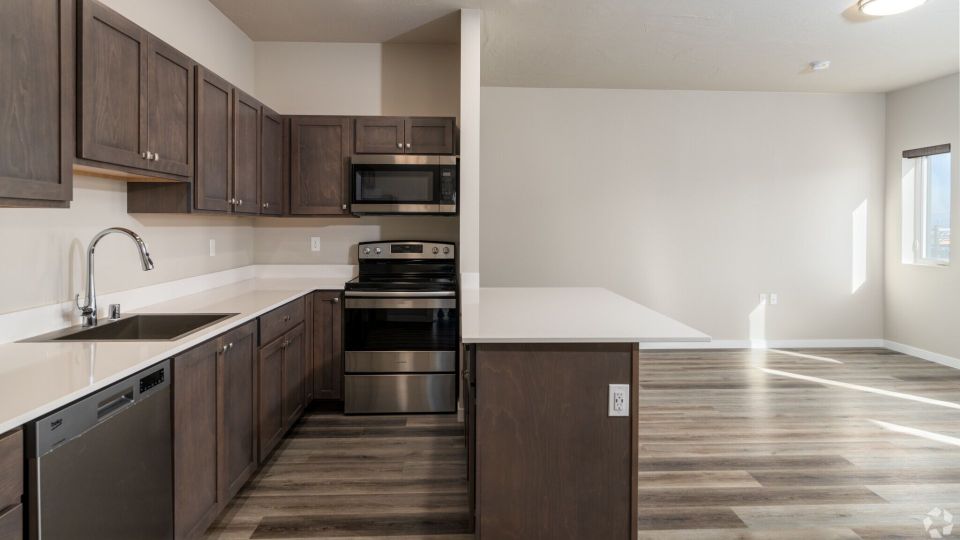 Large kitchen layout with island, walnut cabinets, white countertops, high ceilings, and recessed lighting.