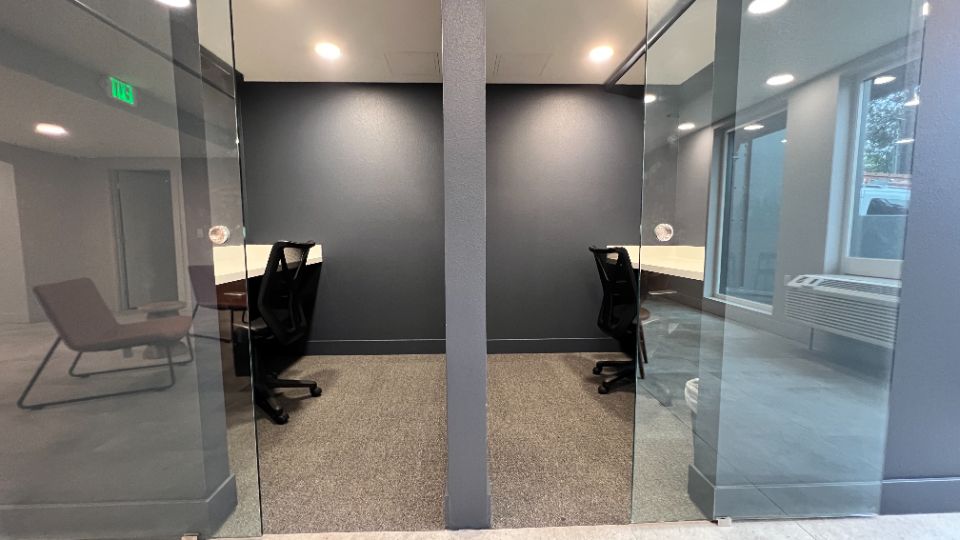 Study pod rooms with desk and sliding glass doors.