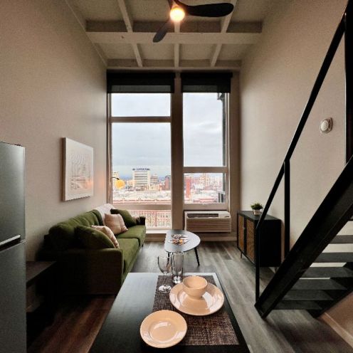 View of a 508 West Studio apartment featuring several vertical windows with shades overlooking Spokane Washington from a high floor.