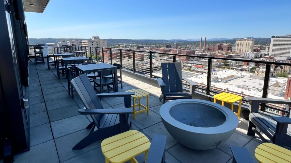 Rooftop deck with cityscape views, modern furniture, BBQ and fire pit.