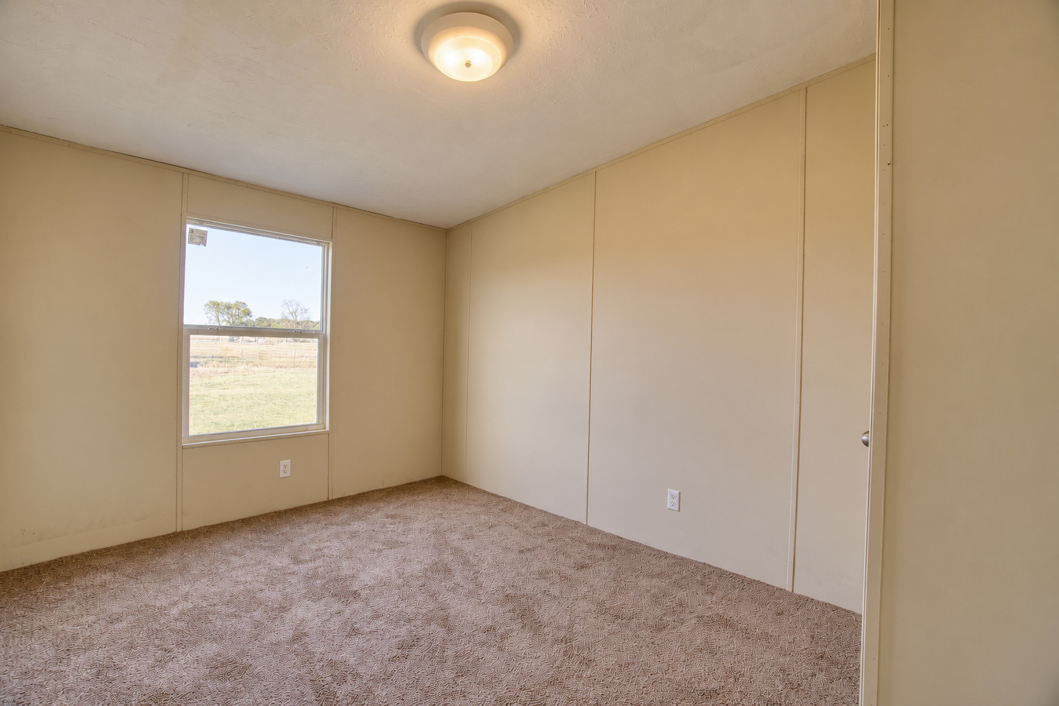 Bedroom with window view of open land - 215 Cale Lane, Calera OK