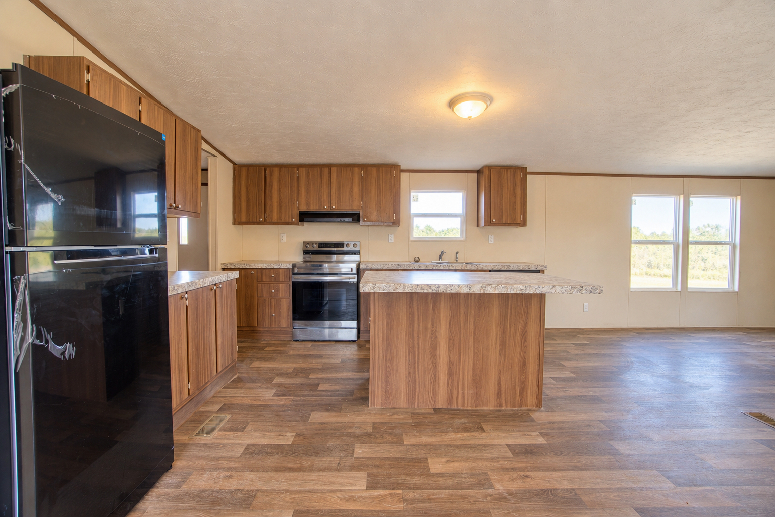 Kitchen with refrigerator, stainless range and island - 215 Cale Lane, Calera OK
