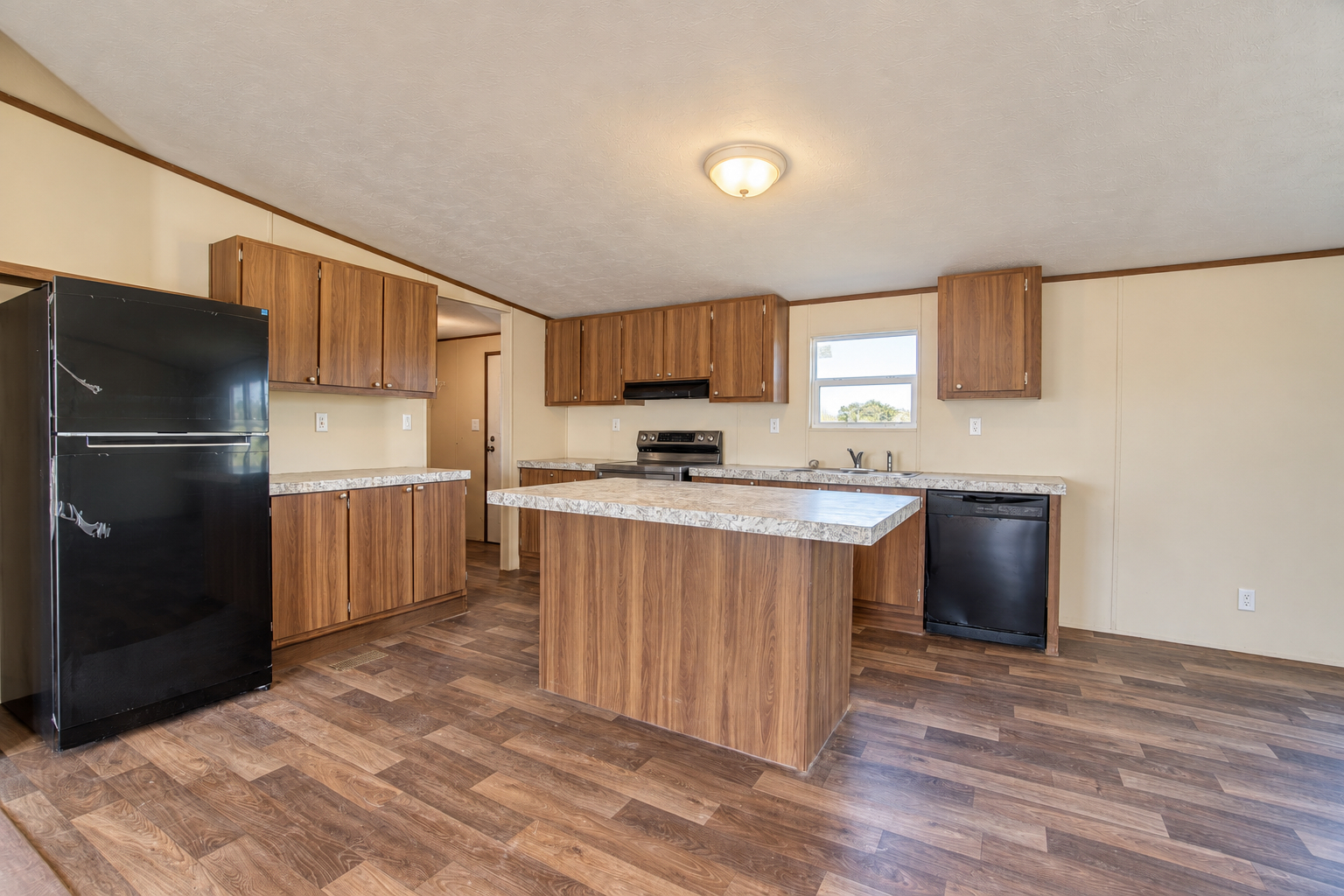 Kitchen with center island and wood cabinetry - 215 Cale Lane, Calera OK