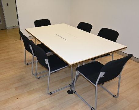 Large Meeting Room with a rectangle table in the middle. 6 chairs have been placed around it.