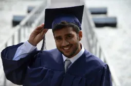 Student at graduation, dressed in graduation gown