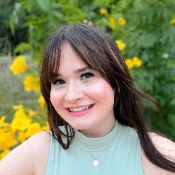 Kendall R, Academic and Executive Function Coach at Coaching Academics, smiling outside surrounded by yellow flowers
