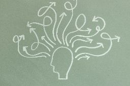 A chalk outline of a head with multiple arrows pointing out and swirling around