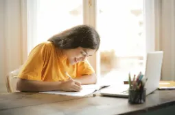 Student working on school work smiling