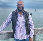 John R, Academic and Executive Function Coach at Coaching Academics  smiling outside at the beach