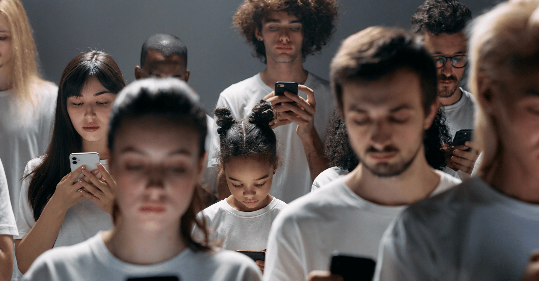 Group of diverse people focused on mobile phones symbolizing reyada's digital experience and communication